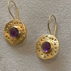 Gold with amethyst stone in the centre of a round disc. AGE 0108